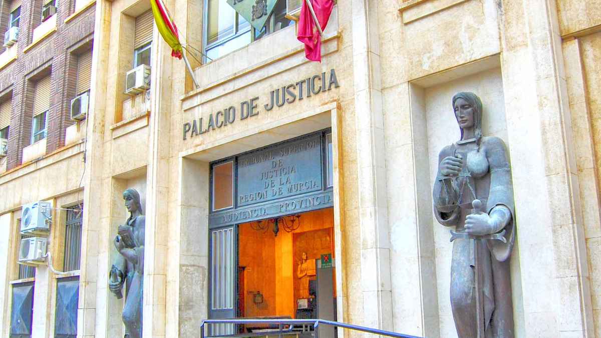 Fachada del Palacio de Justicia de Murcia con estatuas y banderas, donde el TSJ confirmó el pago de 38.600 € por la herencia de 107 fincas