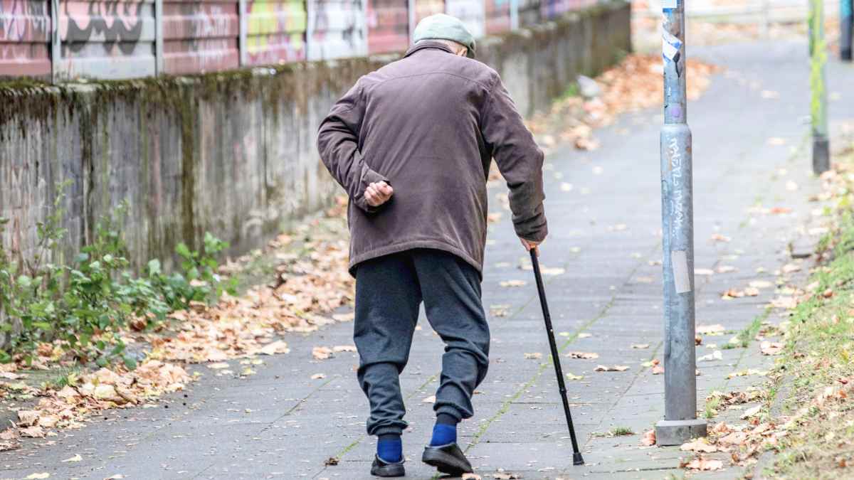 Jubilado con bastón caminando por una acera, representando la historia del anciano que cedió su casa de 750.000 euros a una camarera