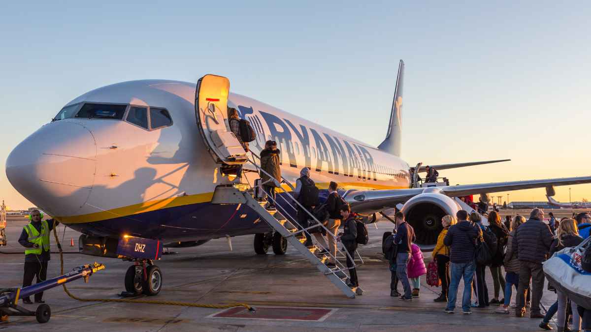 Pasajeros embarcando en un avión de Ryanair en un aeropuerto al atardecer