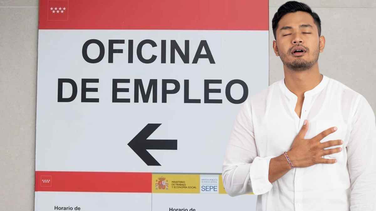 Hombre con gesto de alivio frente al cartel de “Oficina de Empleo” del SEPE