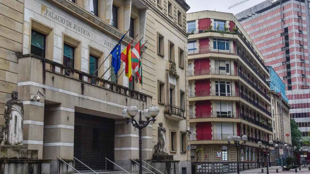 Fachada del Palacio de Justicia de Bilbao, sede del Tribunal Superior de Justicia del País Vasco, con banderas ondeando