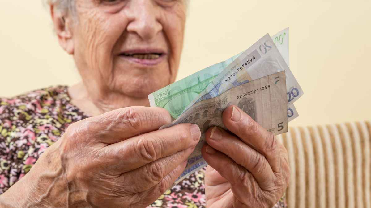Manos de una mujer mayor contando billetes de euro al revisar su pensión de viudedad