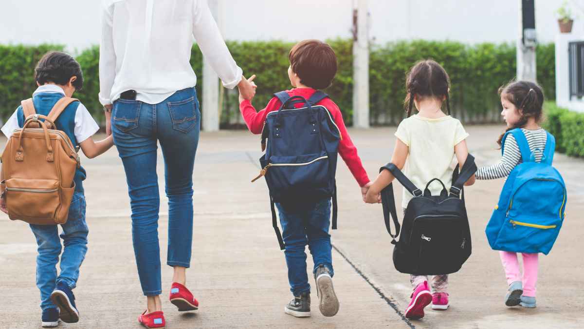 Familia caminando al colegio simboliza la ayuda de 1.000 euros para padres con hijos nacidos desde 2007