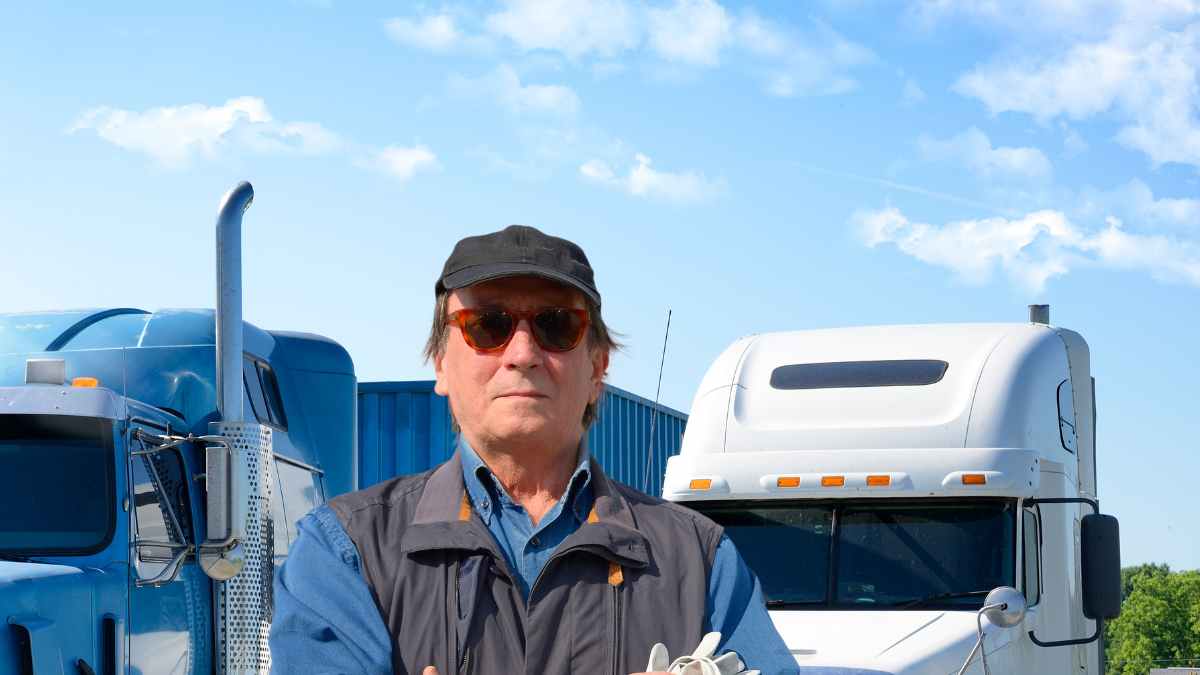 Camionero junto a su camión tras sufrir un infarto por falta de revisiones médicas obligatorias