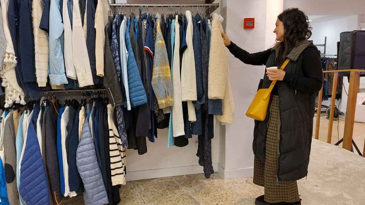 Mujer elige prendas en una tienda Benetton que cerrará dentro del plan de clausura de 419 locales antes de 2025