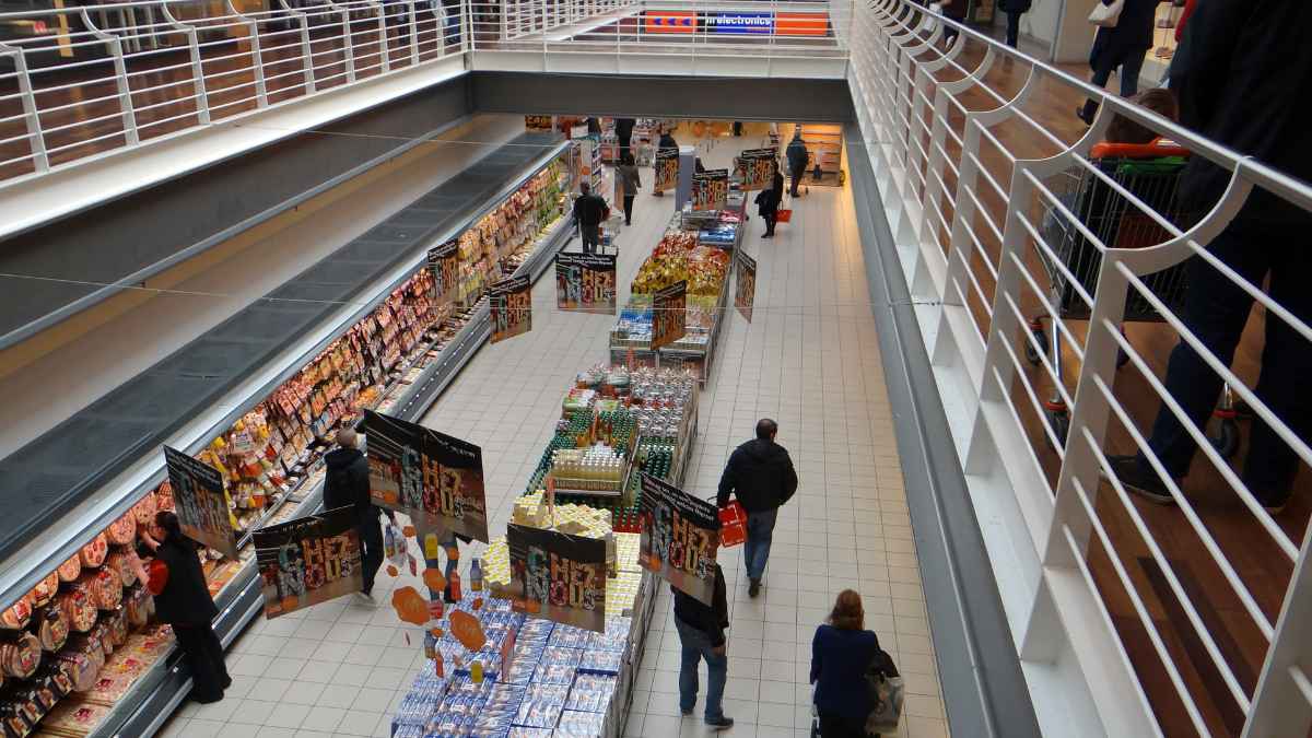 Interior de un supermercado El Arco en Asturias antes de su cierre definitivo, con pocos clientes y lineales de productos frescos