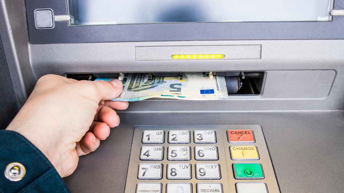 Persona retirando dinero en euros de un cajero automático tras cobrar el paro de junio 2025 del SEPE