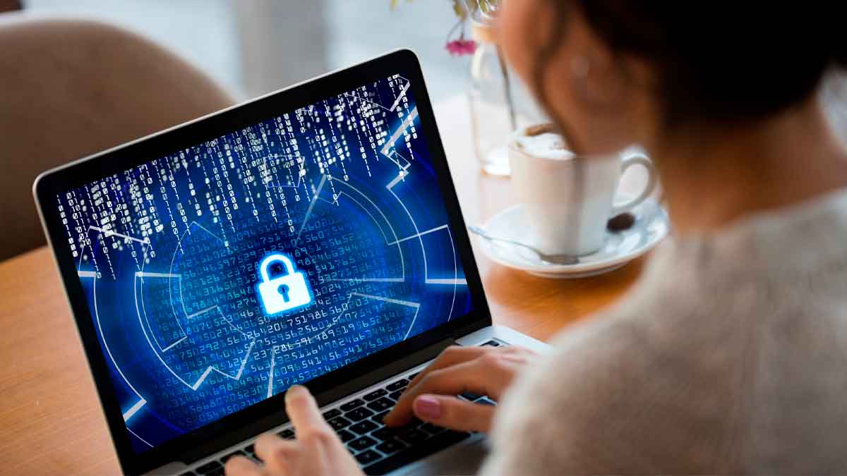 Curso gratuito de ciberseguridad avanzada: mujer trabaja en portátil con candado digital y código binario, simbolizando protección online