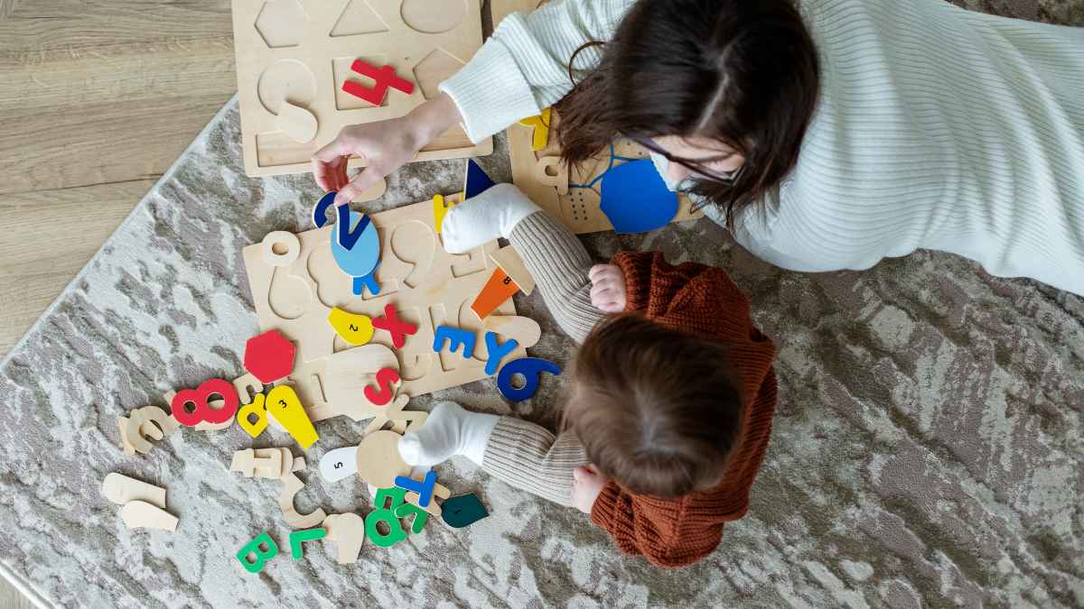 Niñera española jugando con un niño a puzzles de madera en Suiza mientras disfruta de unas “vacaciones pagadas”