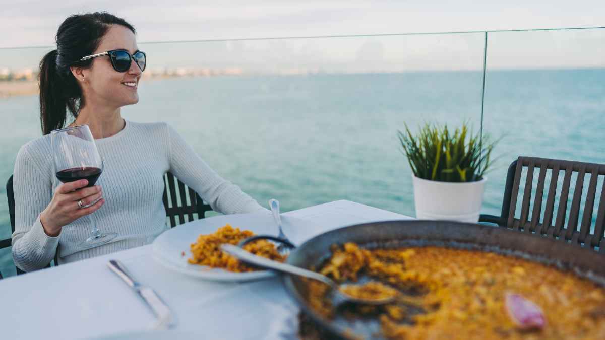 Española disfrutando paella de marisco en restaurante de Estados Unidos con vistas al mar