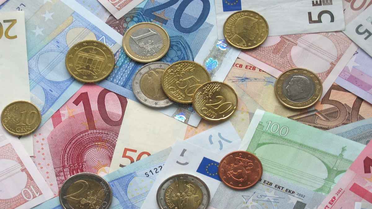 Billetes y monedas de euro que ilustran el ahorro de 10 € tras 20 años en una cuenta bancaria