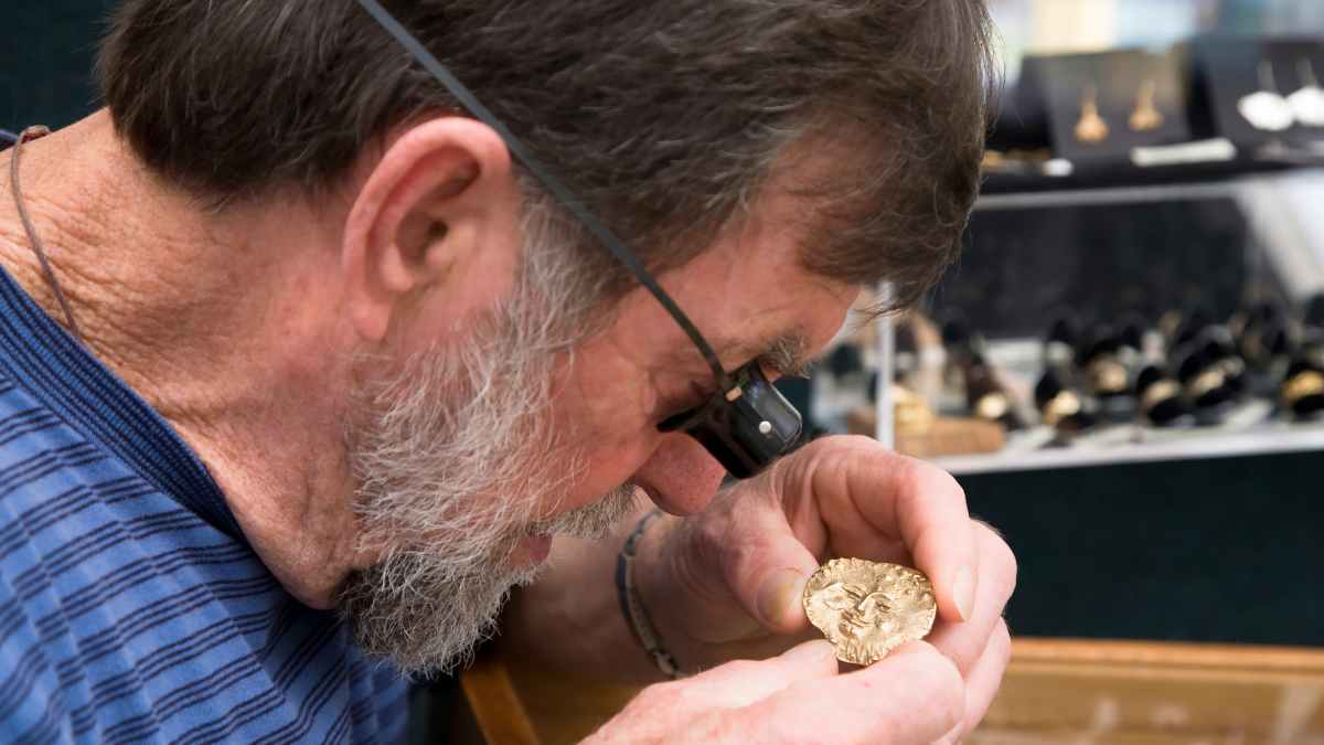 Hombre inspecciona pulsera heredada en joyería con lupa para tasar su autenticidad