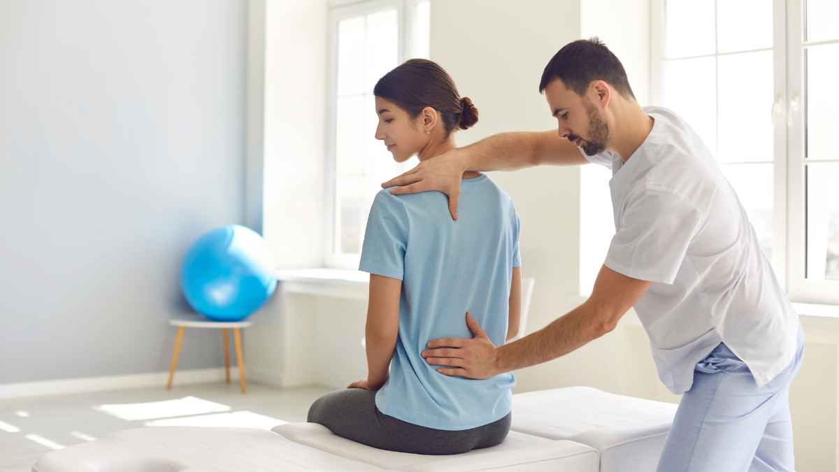 Fisioterapeuta evalúa la espalda de una trabajadora con síndrome de espalda fallida e incapacidad permanente