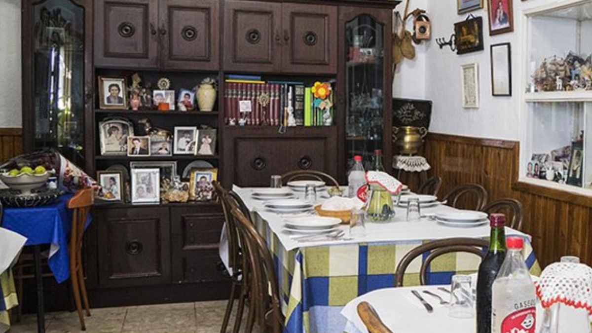 Mesa preparada en el salón familiar de la fonda casa pepa con el menú casero de patatas con huevo y chorizo por 14 euros