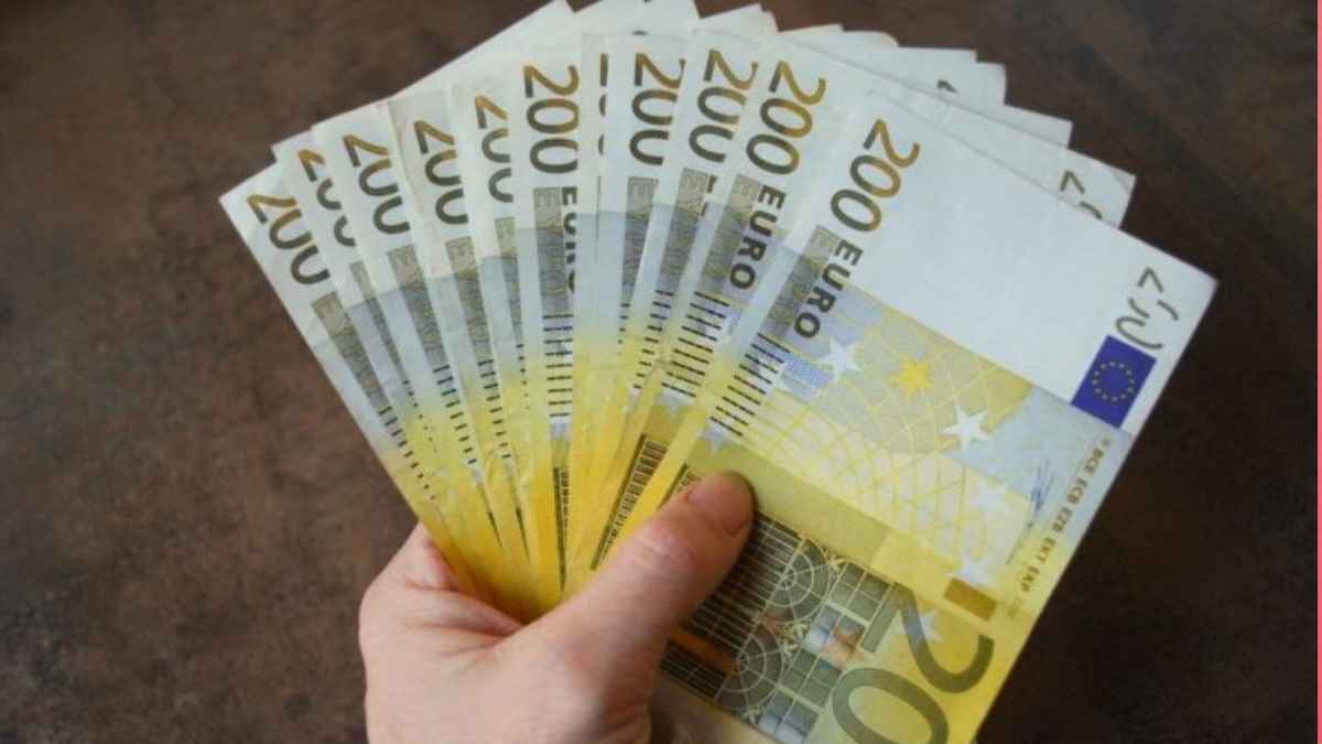 Mano sosteniendo varios billetes de 200 €, símbolo de la Renta Mínima de Inserción en Madrid de hasta 1.134 € mensuales.