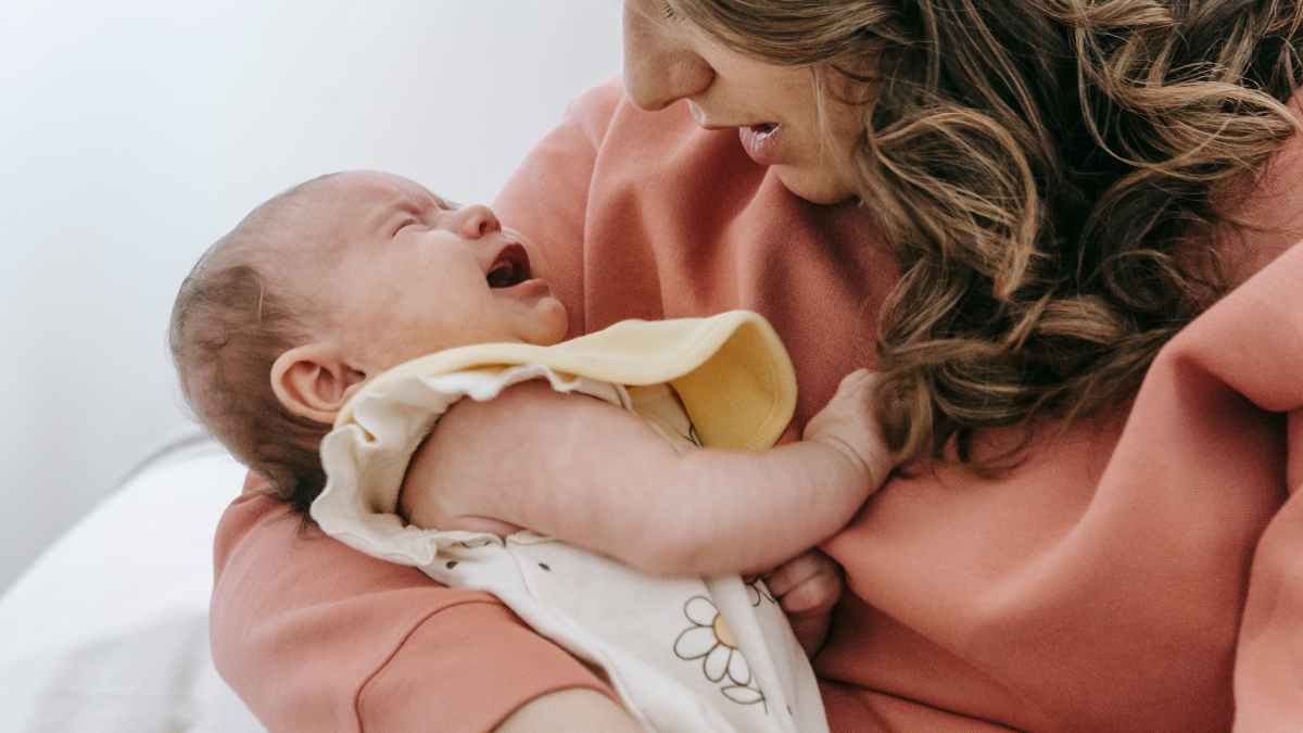 Madre sostiene a su bebé recién nacido en brazos – prestación de 1.000 euros por nacimiento o adopción de la Seguridad Social
