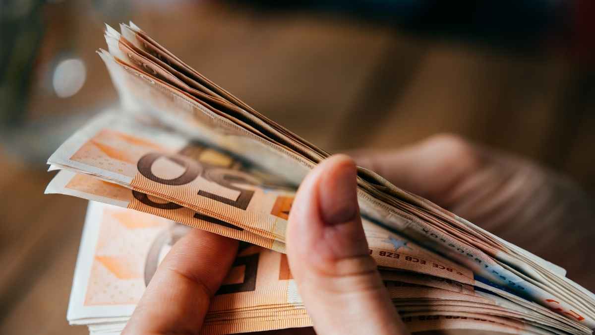 Mano contando billetes de euro que ilustra la paga de 570 euros del SEPE para desempleados
