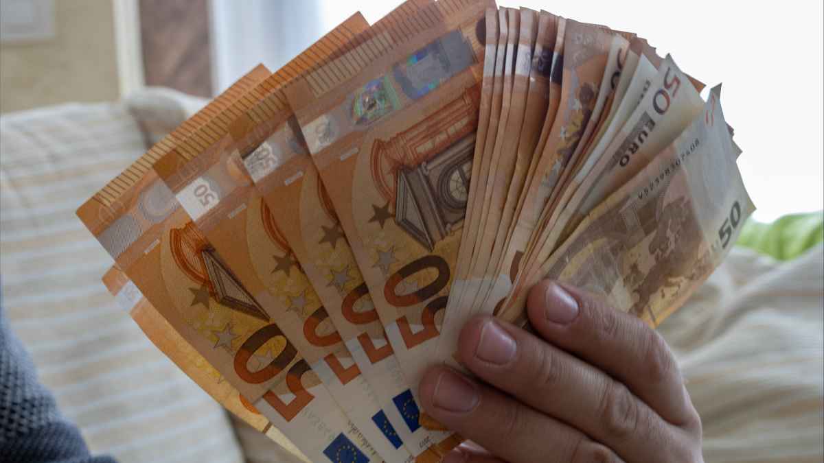 Billetes de 50 euros en mano que ilustran el subsidio del SEPE de 570 € disponible con tres meses cotizados.