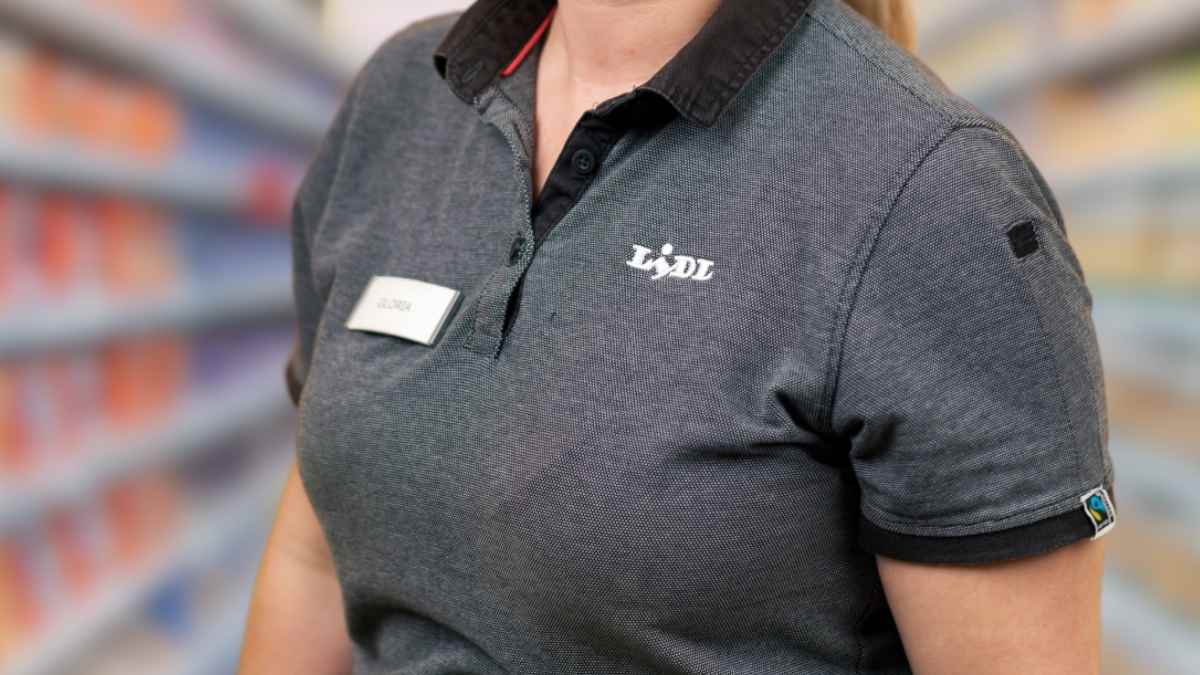 Trabajadora de Lidl con uniforme oficial en el pasillo del supermercado
