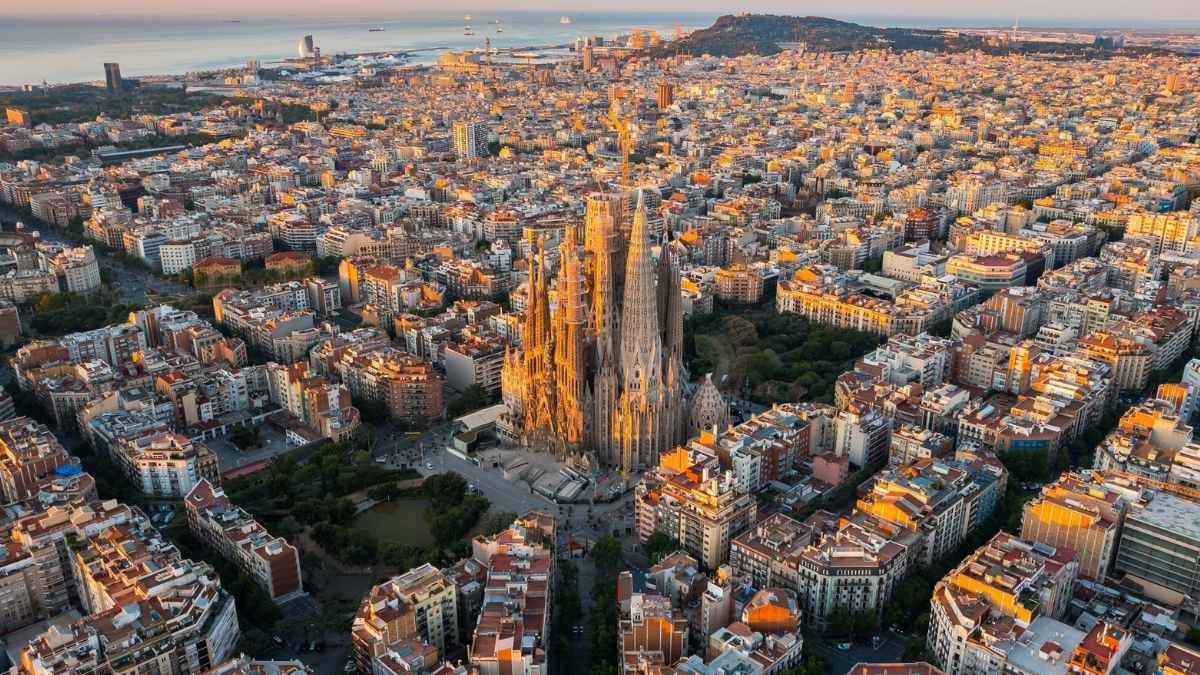 Vista aérea de la Sagrada Familia y barrios residenciales de Barcelona; el alquiler de un piso de 60 m² exige sueldos cinco veces mayores al habitual.