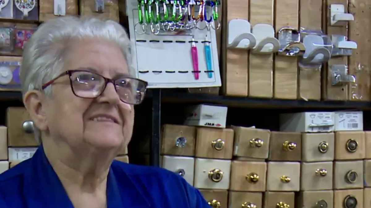 Dependienta veterana sonríe entre cajoneras de herrajes en la ferretería más antigua de Madrid, que cierra tras 72 años.
