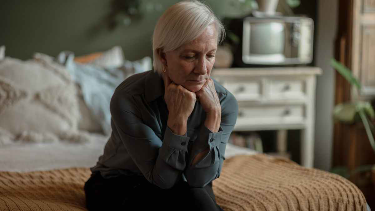 Conchín, pensionista valenciana de 64 años, pensativa sobre una cama en su piso compartido