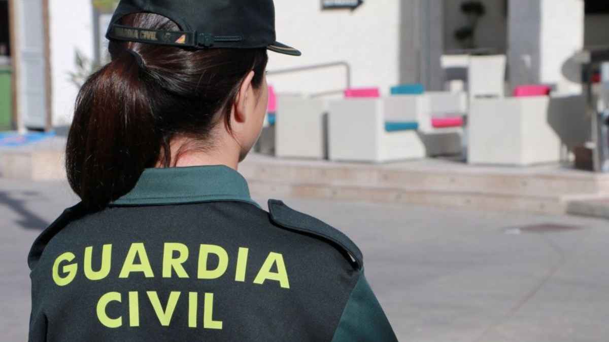 Agente de la guardia civil de espaldas vigilando la vía pública