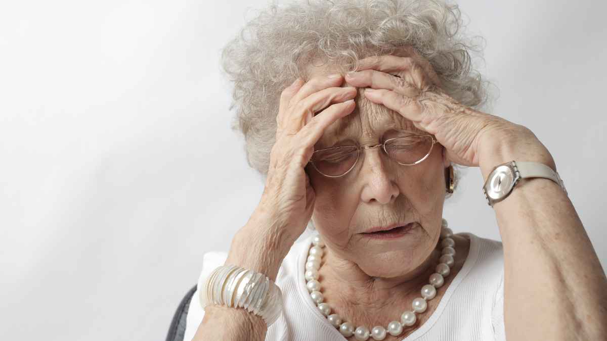 Jubilada indignada fallo administrativo pensión sujetándose la cabeza