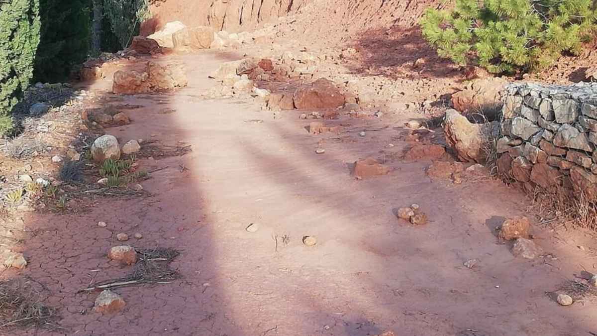 Camino de tierra en Avène bloqueado por rocas enormes que impiden acceso a vivienda de pensionistas.