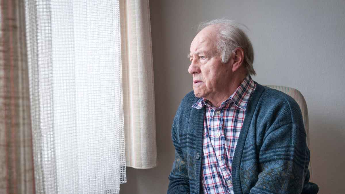 Hombre mayor pensativo tras sentencia que rechaza pensión compensatoria de 450 euros
