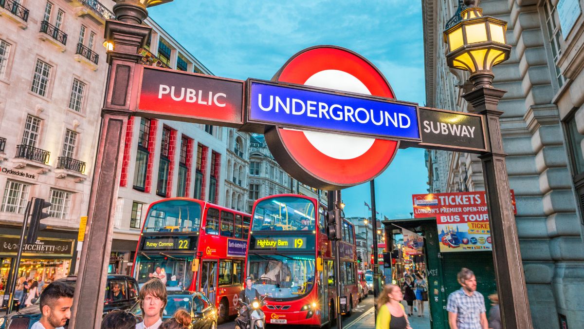 Señal del metro de Londres y autobuses de dos pisos en una calle concurrida del Reino Unido