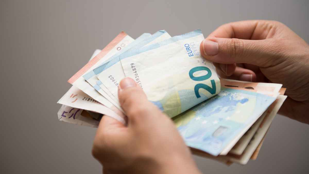 Manos contando billetes de euro que ilustran la ayuda del SEPE de 480 € para mujeres mayores de 45 años en paro