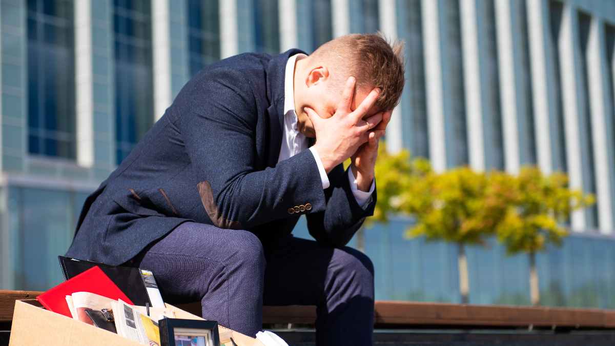 Hombre angustiado tras ser despedido, con caja de pertenencias personales