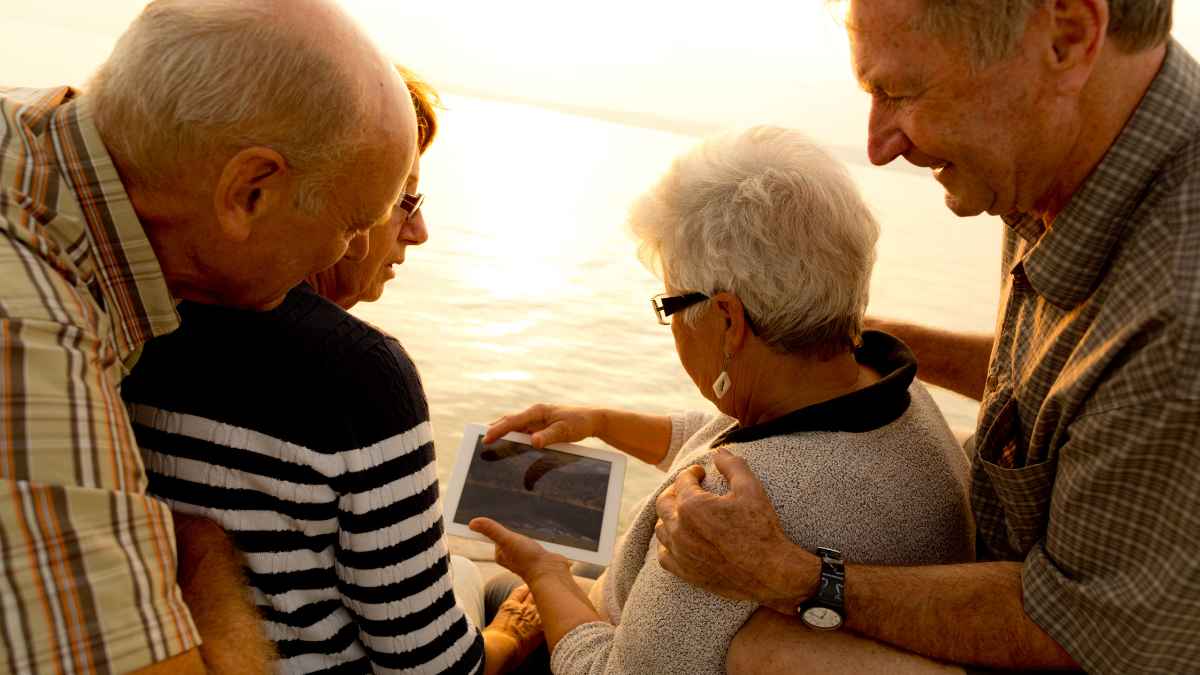Trabajadores jubilados revisando en una tablet si su pensión anticipada a los 63 años supera la mínima