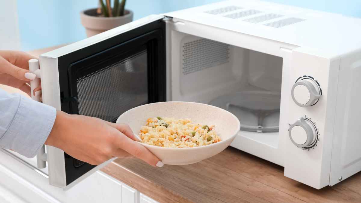 Persona retirando plato de comida del microondas para sustituirlo por horno de convección