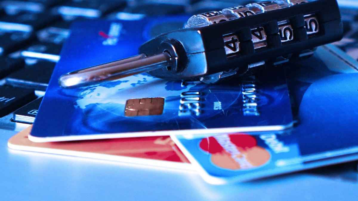 Tarjetas de crédito protegidas con candado sobre teclado, simbolizando el fraude del carding