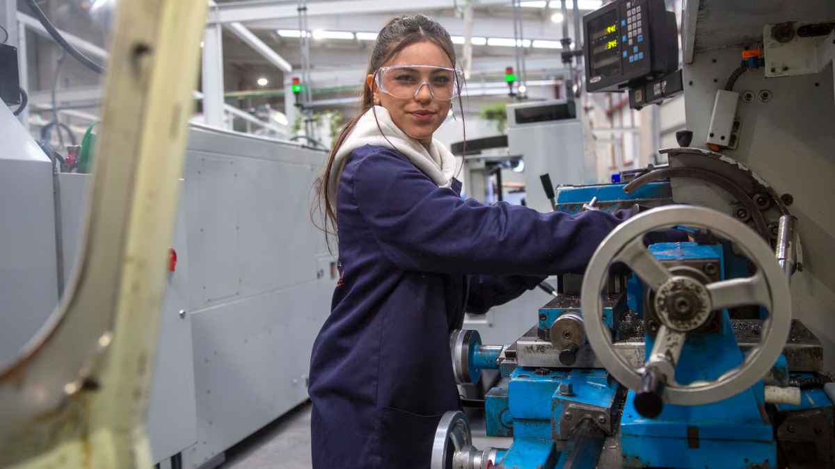 Mujer trabajando en una máquina industrial en un entorno de Formación Profesional (FP), rompiendo estereotipos de género.