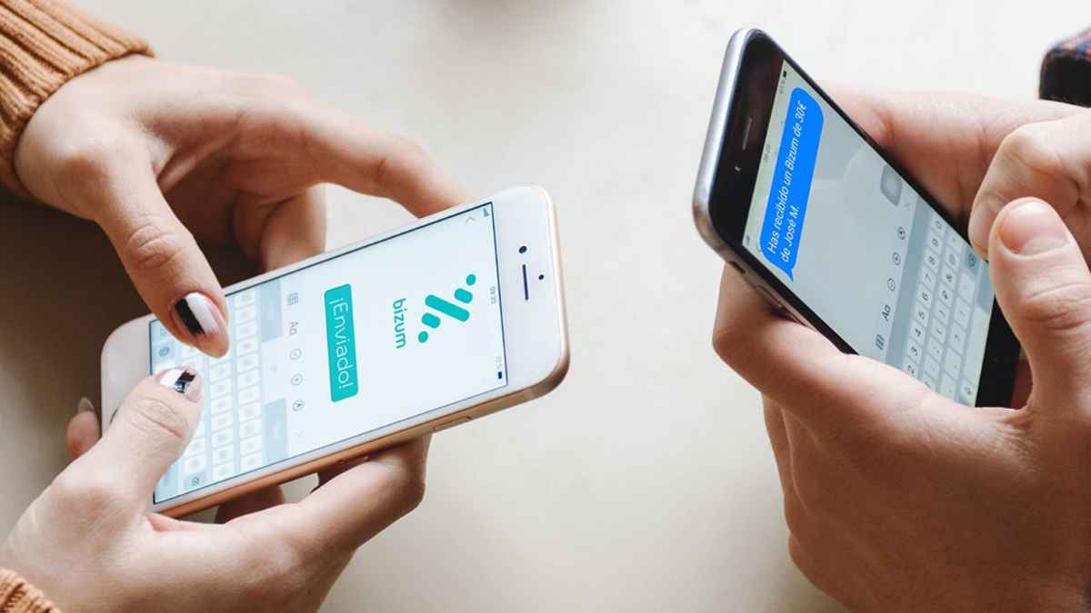 Dos personas usando la aplicación Bizum en sus móviles para enviar y recibir dinero.