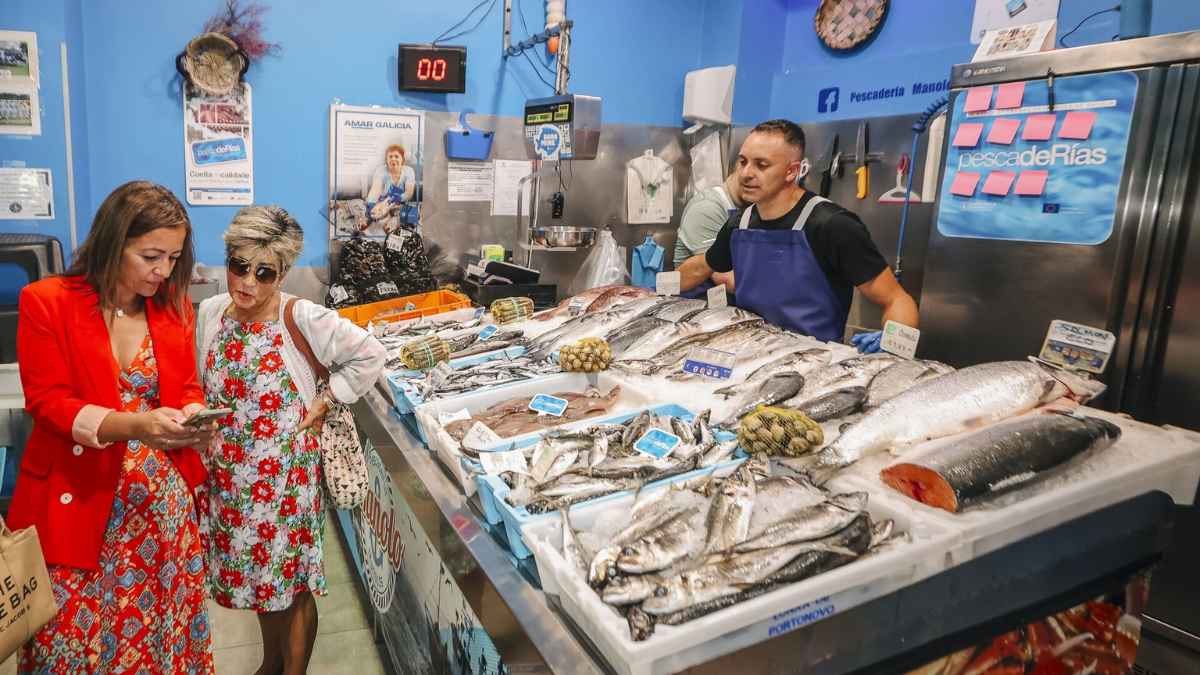 Clientes usando el Bono Peixe de 50 euros en pescadería para descuento en pescado y marisco en Galicia