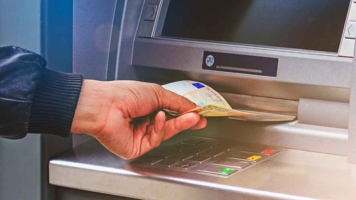 Mano introduciendo billetes de euro en un cajero automático tras un ingreso de 16 500 euros