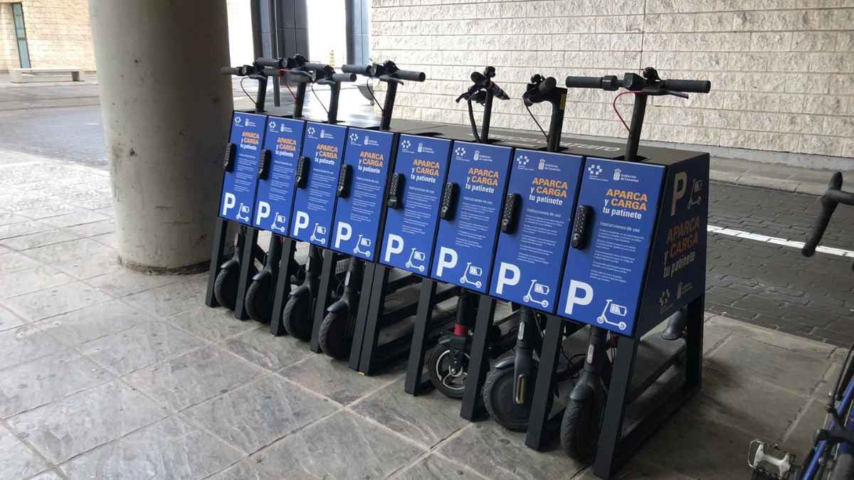 Estación de carga para patinetes eléctricos en la calle con varios patinetes aparcados