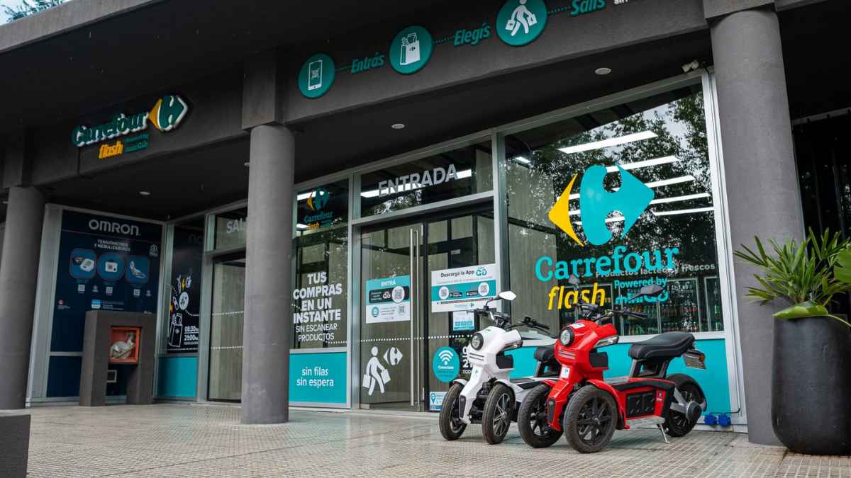 Fachada de tienda Carrefour Flash con motos eléctricas y entrada moderna sin escanear productos, parte de la expansión de Carrefour en España.