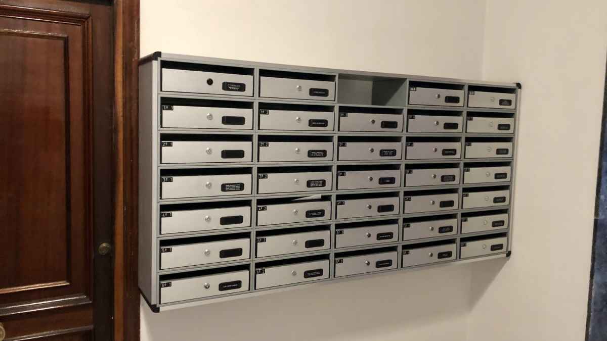 Buzones de cartas en portal de edificio residencial, relacionados con estafa bancaria mediante código QR