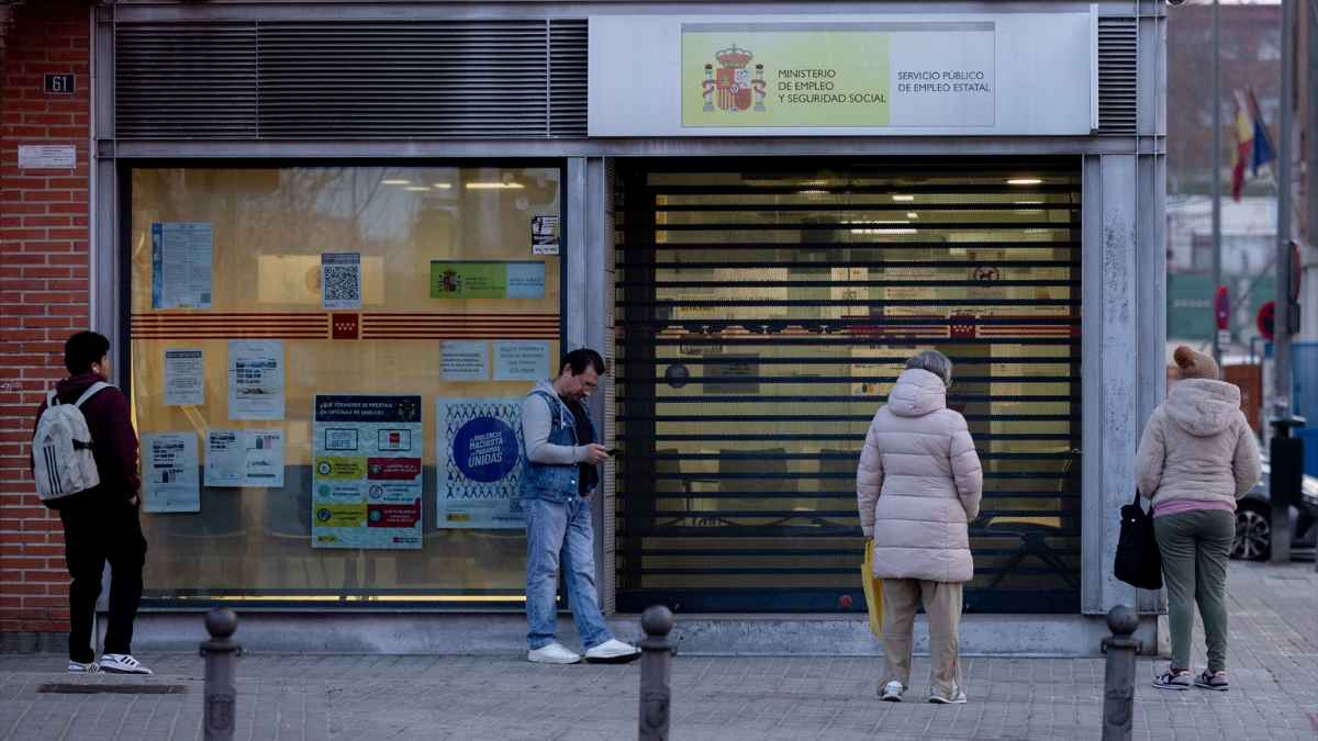Oficina del SEPE con trabajadores esperando información sobre la compatibilidad del paro y sueldo para ingresos bajos.