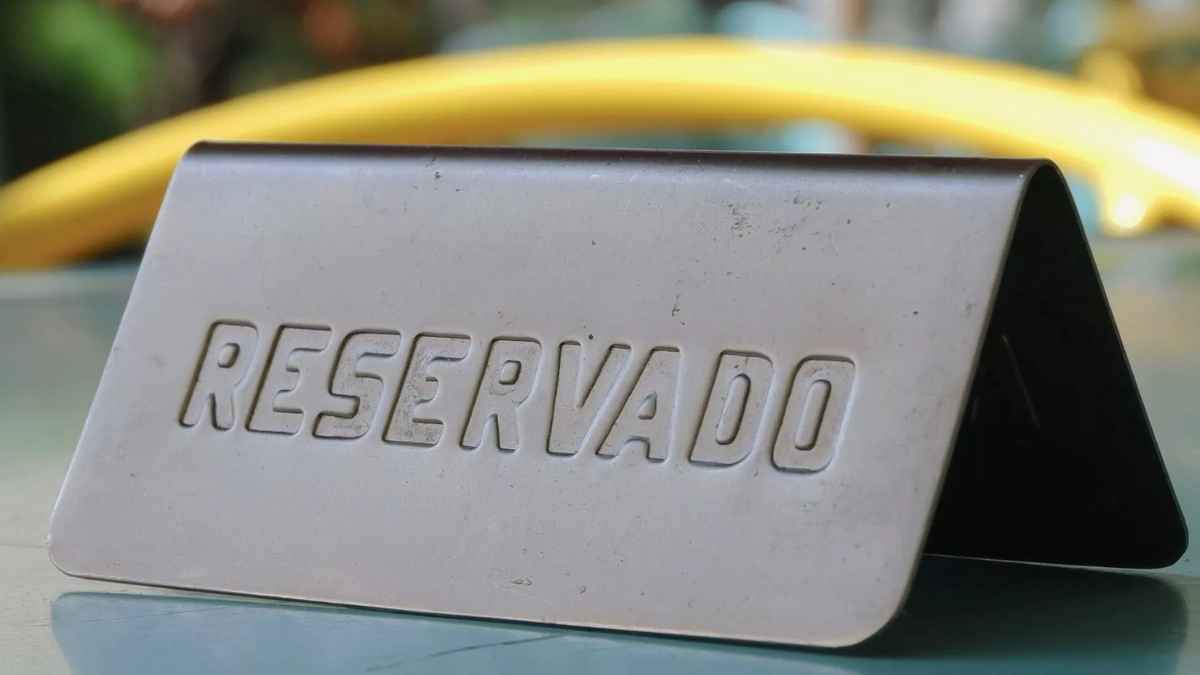 Cartel metálico sobre mesa indicando reservado en restaurante