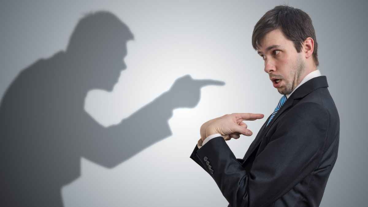 Hombre con traje señalándose a sí mismo y sombra acusadora representando frases típicas de un mentiroso compulsivo