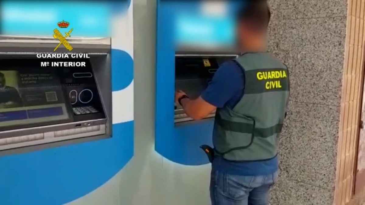 Guardia Civil alertando sobre fraudes en cajeros automáticos mientras un agente utiliza un cajero