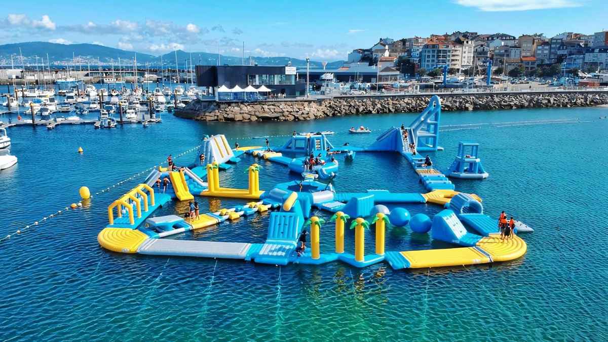 Parque acuático flotante en Galicia con toboganes y plataformas en el agua, ideal para el verano en Sanxenxo.