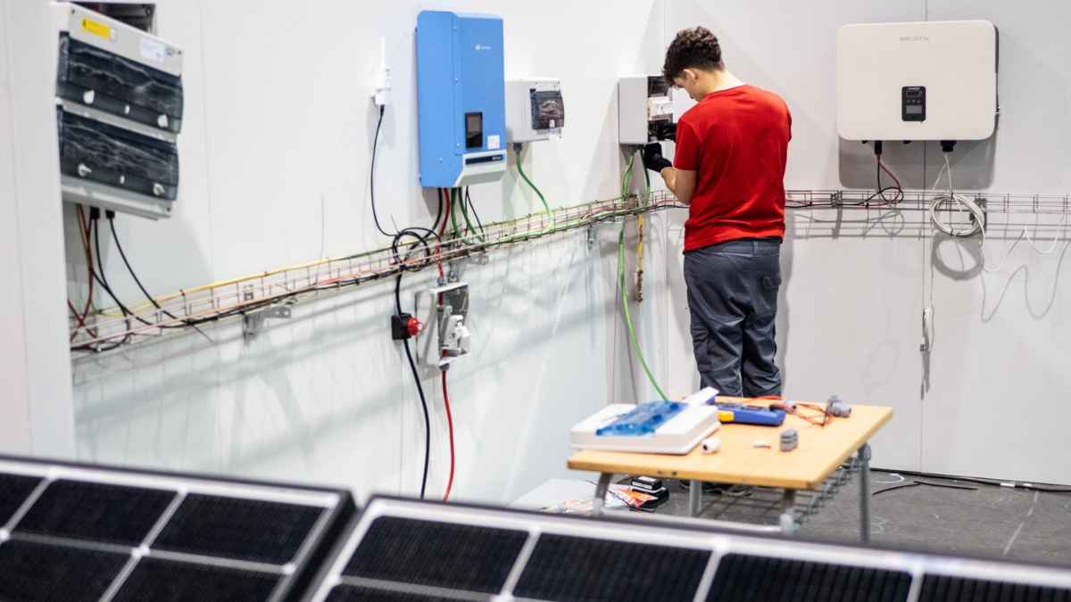 Estudiante de FP en Energías Renovables realizando prácticas en instalación eléctrica con paneles solares.