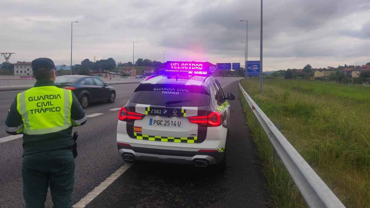 Control de tráfico de la Guardia Civil en carretera con coche patrulla y agente realizando inspección